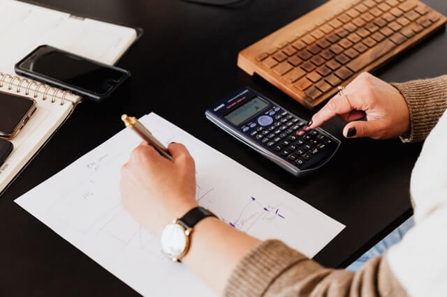 Καλωσόρισμα Crop Woman Using Calculator And Taking Notes On Paper